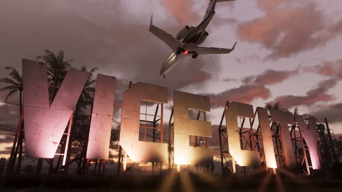 Screenshot de GTA VI: um avião passa sobre o letreiro de Vice City ao entardecer.
